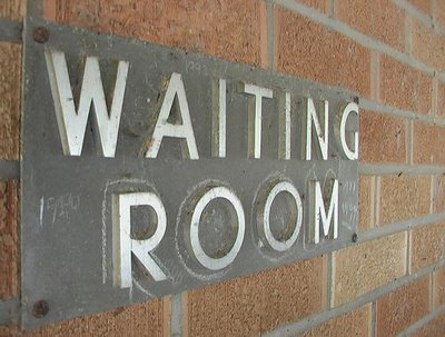 waiting room sign on brick wall